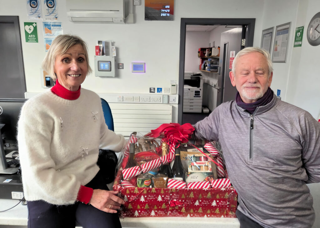 Miss Patricia Logan presents James Stothers with the Christmas Hamper that he won in the Ladies Section Christmas Draw